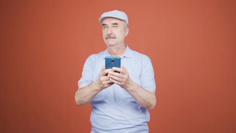 Happy-old-man-texting-on-the-phone.-Smiling.